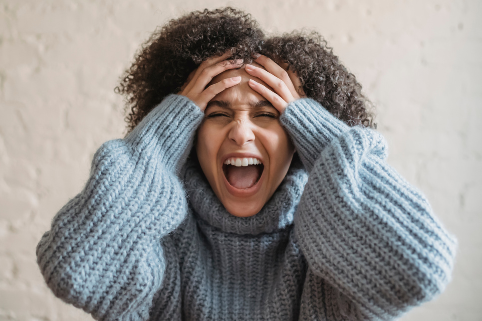 Upset ethnic woman screaming in room